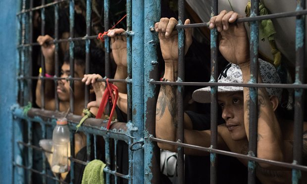 Inmates look outside from an overcrowded police jail cell in Manila, Philippines.